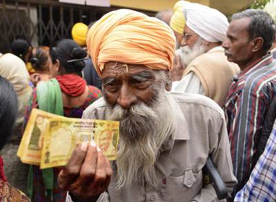 A retired police personnel waits outside to deposit and exchange 500 and 1,000 rupee notes in Amritsar, India. Sameer Sehgal / Hindustan Times via Getty Images