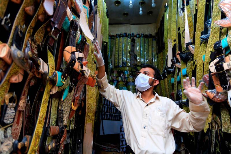 A merchant of "janbiyas", Yemeni short curved daggers, displays his merchandise in Yemen's capital Sanaa on May 20, 2020, as Muslims shop ahead of the Eid Al Fitr holiday amidst a coronavirus outbreak.  AFP