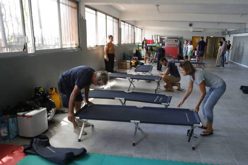 Tourists prepare camp beds in a gym in the city of Ajaccio, Corsica. Getty Images