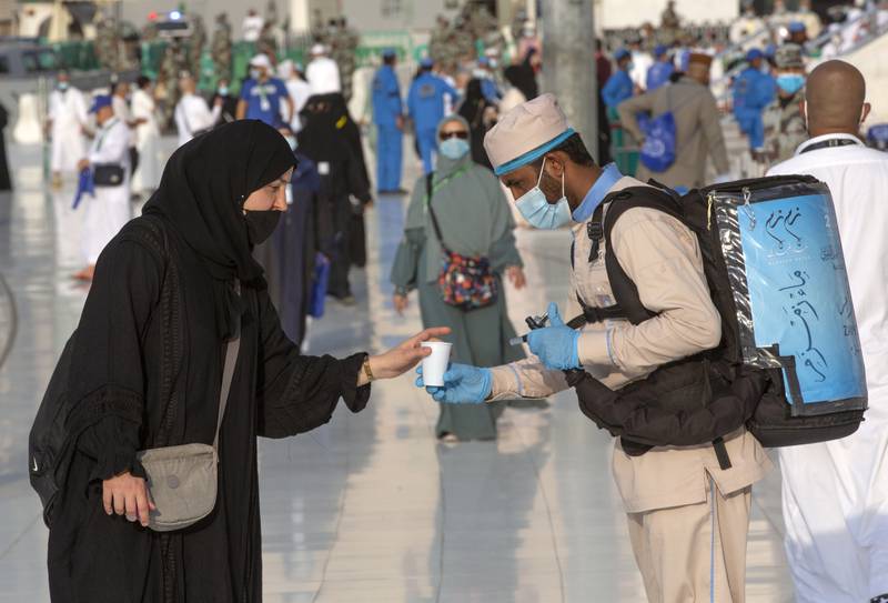 A worker distributes free water from the holy well of Zamzam to pilgrims.