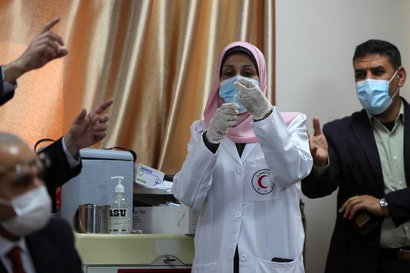 A health worker holds a syringe containing the Covid-19 vaccine in Gaza city. Reuters