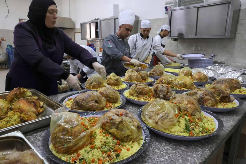 Cooks employed by the Islamic Charitable Society prepare iftar meals for Palestinian orphans and families in need, in the West Bank city of Hebron. AFP
