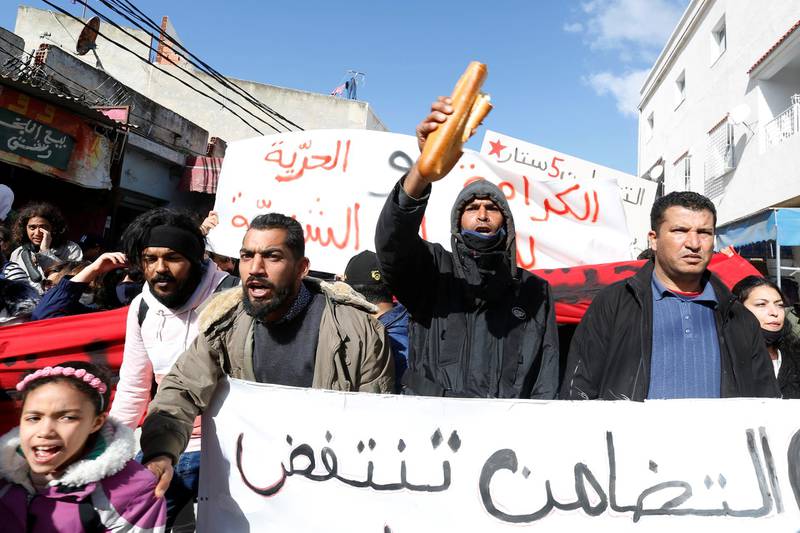Demonstrators carry signs during an anti-government protest in Tunis. Reuters