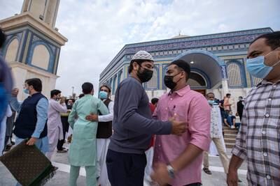 Worshippers embrace after morning prayers in Abu Dhabi. Victor Besa / The National