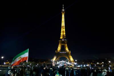 Protesters holds Iran's former flag on the Trocadero Esplanade Trocadero Esplanade during an event to display the slogan "Woman.  Life.  Freedom. " on the Eiffel Tower, in a show of support to the Iranian people, in the wake of the death of young Iranian woman Masha Amini who died in the country's morality police custody, in Paris, on January 16, 2023. AFP