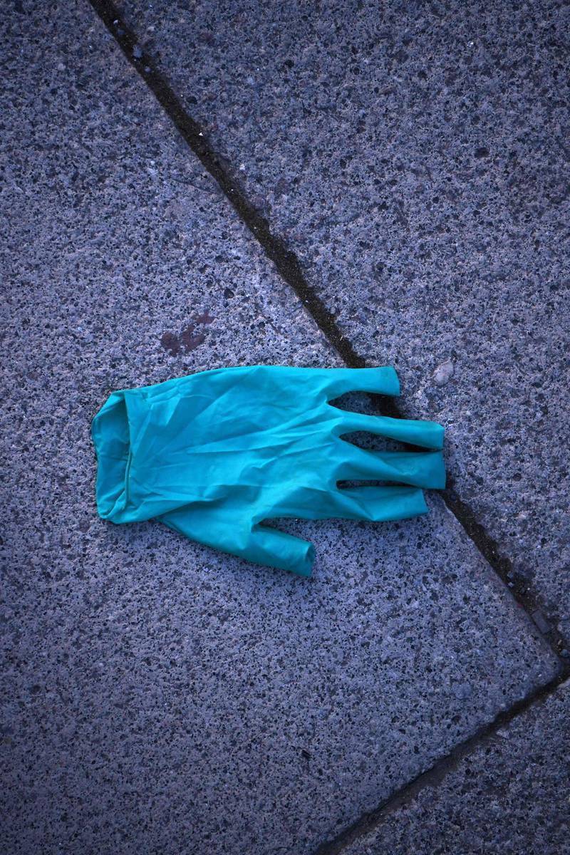 A discarded plastic glove is pictured in London on the morning on March 24, 2020 after Britain ordered a lockdown to slow the spread of the novel coronavirus. Britain was under lockdown March 24, its population joining around 1.7 billion people around the globe ordered to stay indoors to curb the "accelerating" spread of the coronavirus. / AFP / DANIEL LEAL-OLIVAS
