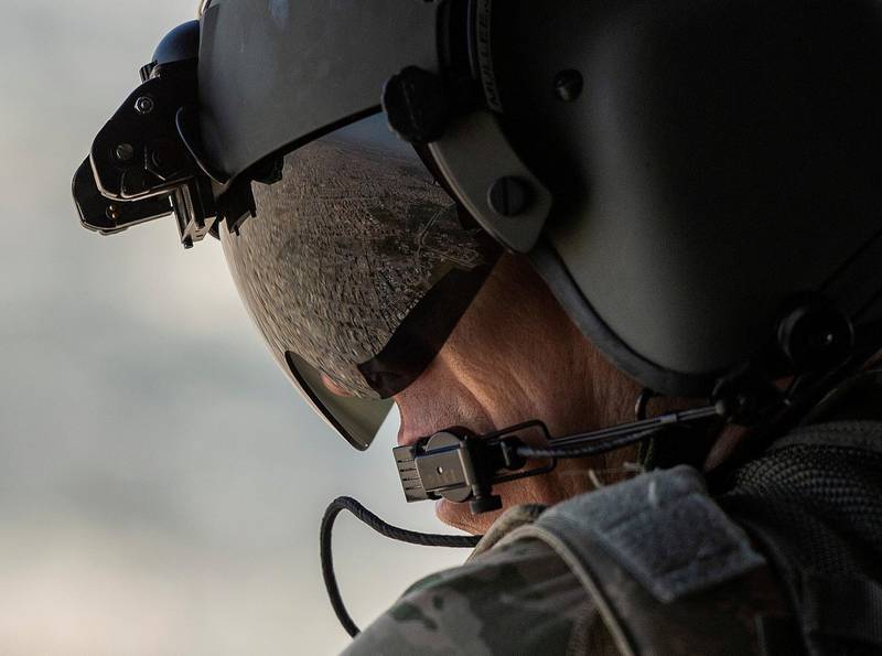 FILE PHOTO: A partial view of the Iraqi capital Baghdad is reflected in the visor of a U.S. Army helicopter crew member as he looks out of a Chinook helicopter flying from the U.S. Embassy to Baghdad International airport on January 9, 2019.  Andrew Caballero-Reynolds/File Photo