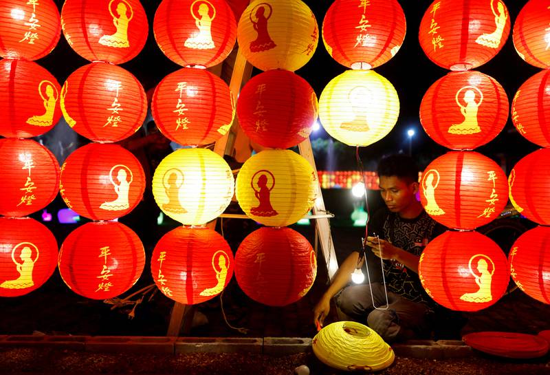 A worker installs lanterns before the Chinese Lunar New Year at a Buddhist temple in Jenjarom, Malaysia. Reuters
