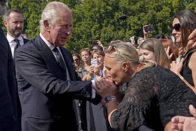 A well-wisher kisses the hand of King Charles III outside  Buckingham Palace after the death on Thursday of Queen Elizabeth II. King Charles, who spent much of his 73 years preparing for the role, on Friday planned to meet the prime minister and address a nation grieving the only British monarch most of the world had known.  He takes the throne in an era of uncertainty for his country and the monarchy itself.  AP