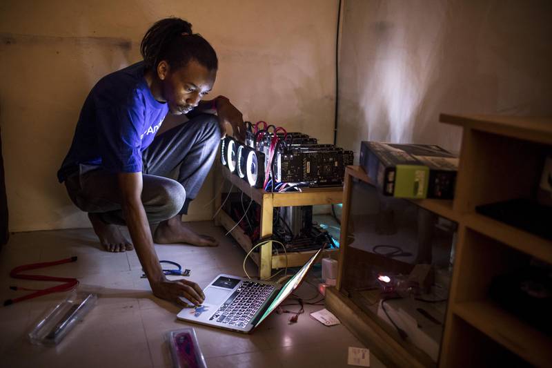 Eugene Mutai, bitcoin 'miner' and software developer, operates a laptop computer connected to a rack of cryptocurrency 'mining' machines at his home in Nairobi, Kenya, on Saturday, Sept. 9, 2017. Cryptocurrencies are especially attractive in economies where there are restrictions on taking cash abroad, or people don’t have bank accounts, or the local currency is being trampled by inflation. Photographer: Luis Tato/Bloomberg