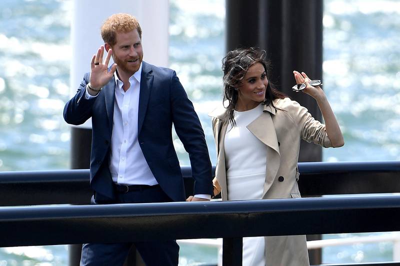 Prince Harry and Meghan wave as they arrive at the Opera House in Sydney. AP Photo