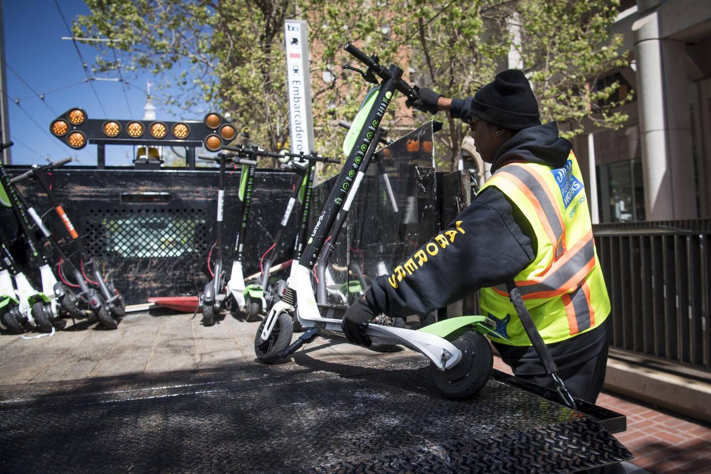 A City of San Francisco Public Works employee loads a Neutron Holdings Inc. LimeBike shared electric scooter onto the back of a truck in San Francisco, California, U.S., on Wednesday, May 2, 2018. City officials, eager to do something about the electric scooters issue, are sending cease-and-desist letters and are planning to require permits soon, while impounding any that they say are parked illegally. Photographer: David Paul Morris/Bloomberg