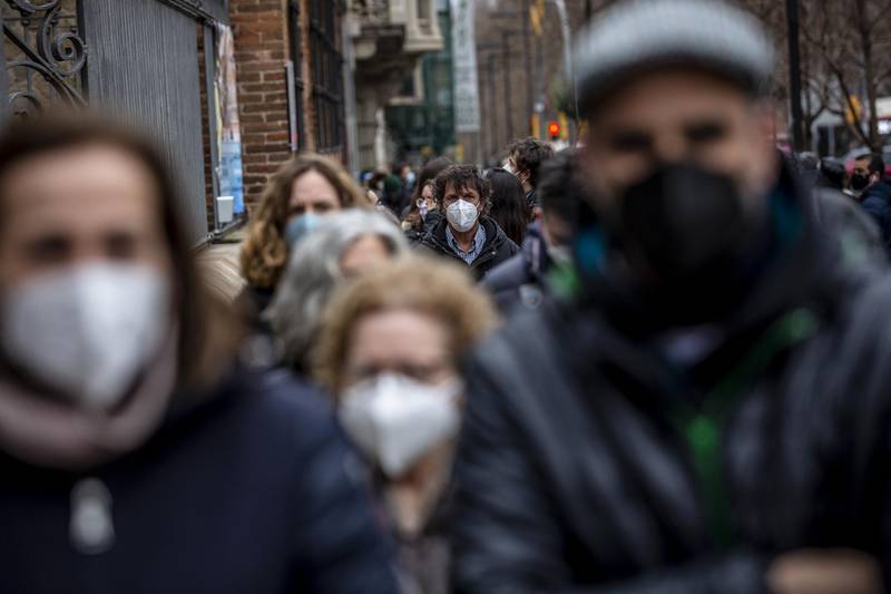 Masked voters wait in line at a polling station in Barcelona, Spain. Bloomberg