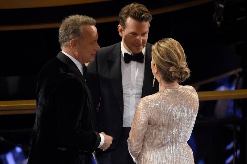 Tom Hanks, from left, Bradley Cooper and Rita Wilson speak in the audience at the Oscars. AP