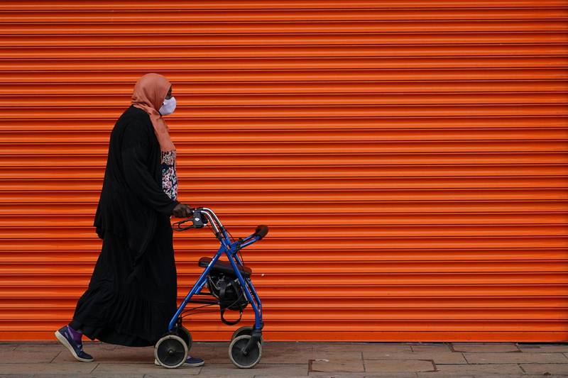 A woman walks past a shuttered shop front in Middlesbrough. Getty Images