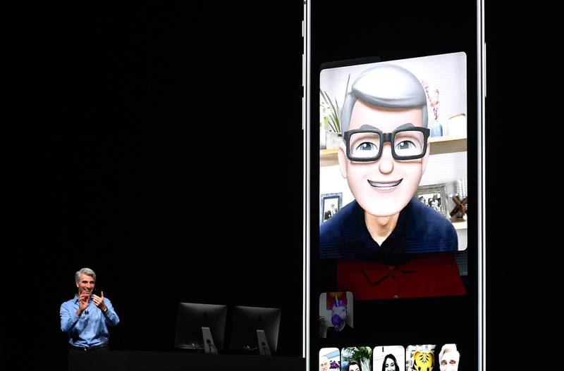 Apple CEO Tim Cook (L) speaks using his Memoji during a group FaceTime call on stage during Apple's Worldwide Developer Conference (WWDC) at the San Jose Convention Centerin San Jose, California on Monday, June 4, 2018.  / AFP / Josh Edelson
