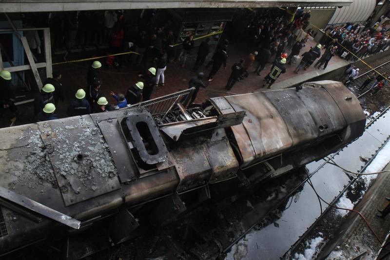 TOPSHOT - Fire fighters and onlookers gather at the scene of a fiery train crash at the Egyptian capital Cairo's main railway station on February 27, 2019.  The crash killed at least 20 people, Egyptian security and medical sources said.
The accident, which sparked a major blaze at the Ramses station, also injured 40 others, the sources said.
 / AFP / Hussein Talal
