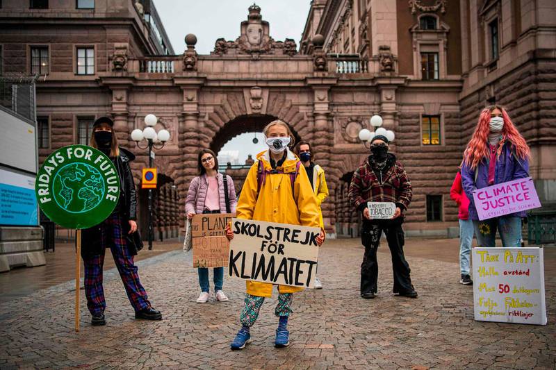 Swedish climate activist Greta Thunberg protests with her placard reading "School strike for climate"  as part of her Fridays for Future protest in front of the Swedish Parliament Riksdagen in Stockholm on October 9, 2020.  / AFP / Jonathan NACKSTRAND
