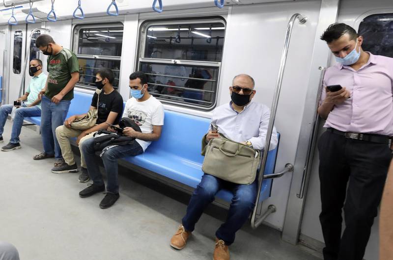Egyptians wearing protective face masks at the underground Al Shohadaa metro station in Cairo.  EPA