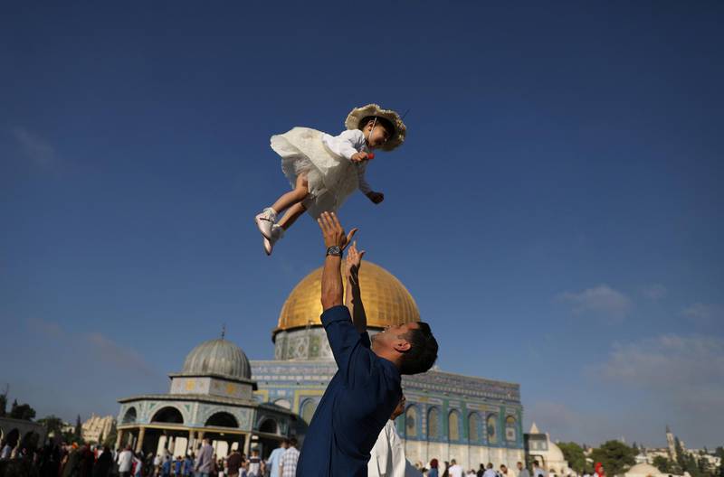 A Palestinian man throws his child in the air following morning prayers marking the first day of Eid al-Adha celebrations, on the compound known to Muslims as al-Haram al-Sharif and to Jews as Temple Mount in Jerusalem's Old City. Reuters