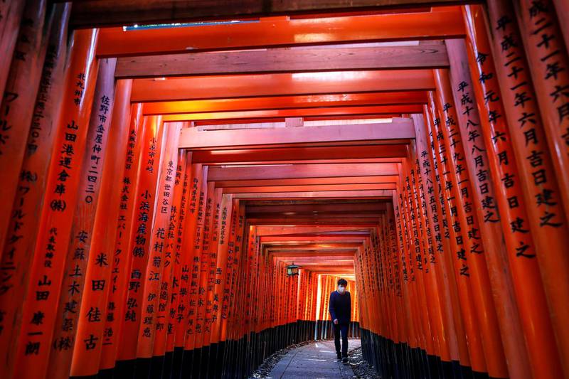 epaselect epa08419145 A man wearing a protective face mask walks through the Senbon Torii (Thousands Torii Gates), a tunnel of torii gates, at Fushimi Inari Taisha Shrine in Kyoto, Japan, 13 May 2020, amid the ongoing coronavirus COVID-19 pandemic. The streets of Japan's ancient capital Kyoto and its world-famous tourist spots are largely deserted as the number of foreign visitors declined more than 93 per cent from previous year, the local media reported in late April. Japan's tourism industry has been hit hard by the COVID-19 crisis risking millions of jobs. The Japanese government extended the nationwide state of emergency until 31 May, in a bid to curb the spread of the coronavirus SARS-CoV-2 which causes the COVID-19 disease.  EPA-EFE/DAI KUROKAWA *** Local Caption *** 56083142