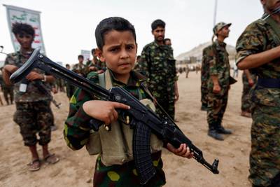 A Yemeni boy poses with a Kalashnikov assault rifle during a gathering of newly-recruited Huthi fighters in the capital Sanaa, to mobilize more fighters to battlefronts in the war against pro-government forces in several Yemeni cities, on July 16, 2017. (Photo by Mohammed HUWAIS / AFP)