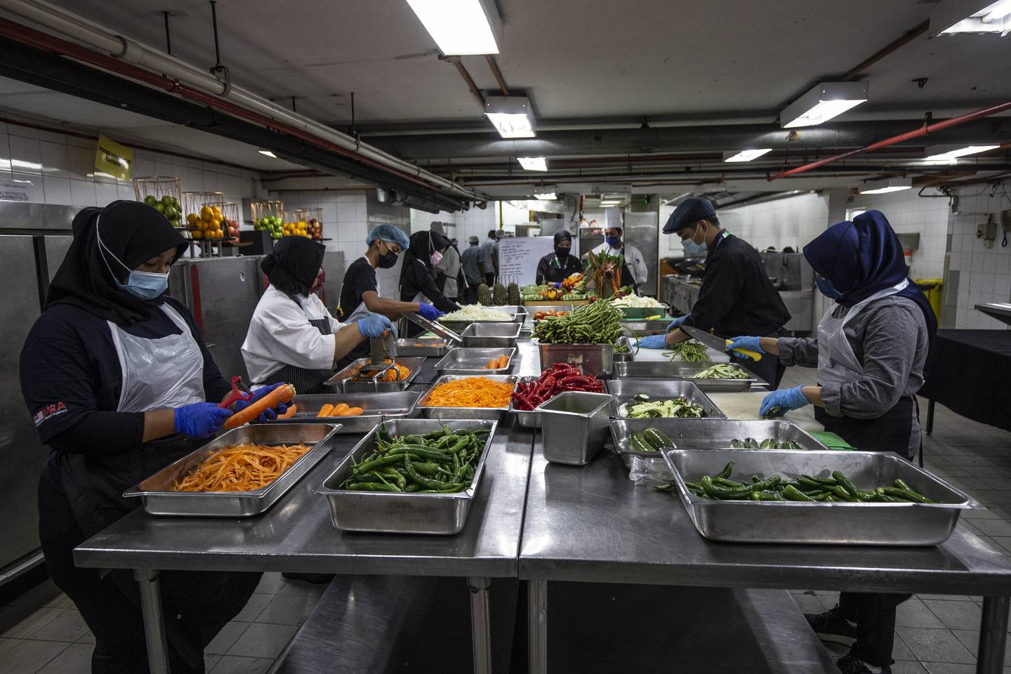 Hotel staff prepare vegetables for cooking in a kitchen of the Grand Seasons Hotel in Kuala Lumpur this month.  Many suchy enterprises prepare 1,000 portions daily of food for homeless people and frontliners. EPA
