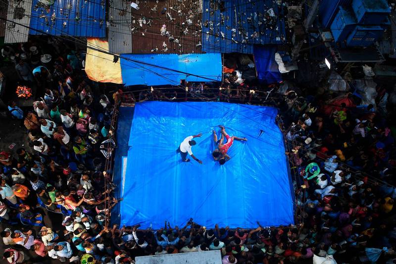Amateur wrestlers participate in a friendly wrestling competition on a make-shift ring at the junction of a busy road organised as part of Diwali festivities in Kolkata on October 26, 2019.  AFP