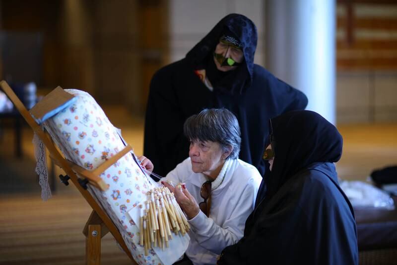 A Brazilian artisan learns the Emirati Talli braid-weaving craft from Irthi craftswomen, at the Sao Paulo International Book Fair in 2018. Photo: Irthi Contemporary Crafts Council