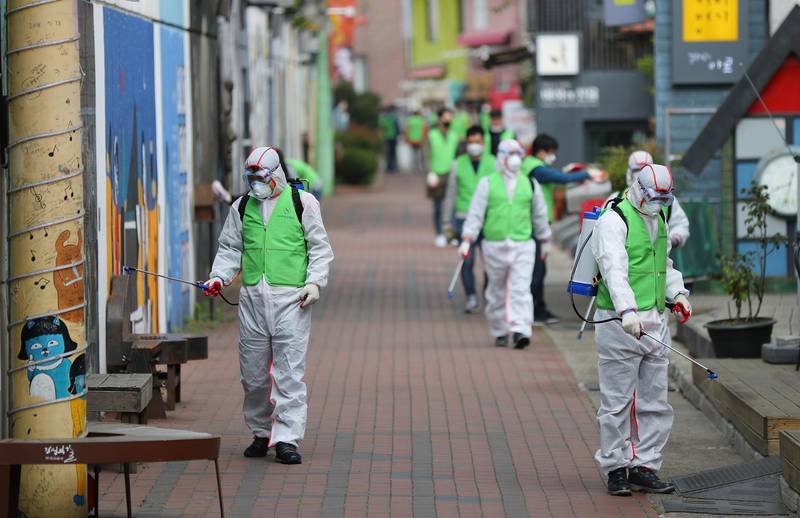 Health workers disinfect a street to curb the spread of coronavirus,  Daegu, South Korea, 11 April. EPA