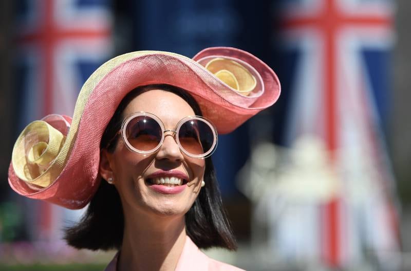 A race-goer poses in an extravagant hat. EPA