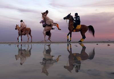 Emiratis ride horses at sunset in Abu Dhabi. AFP