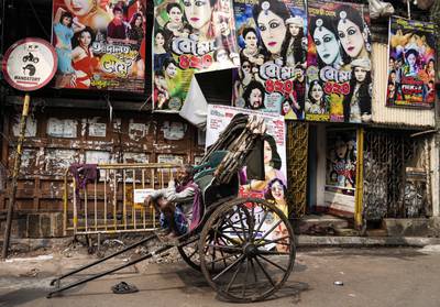 An Indian hand rickshaw puller waits for customers in Kolkata, India. AP