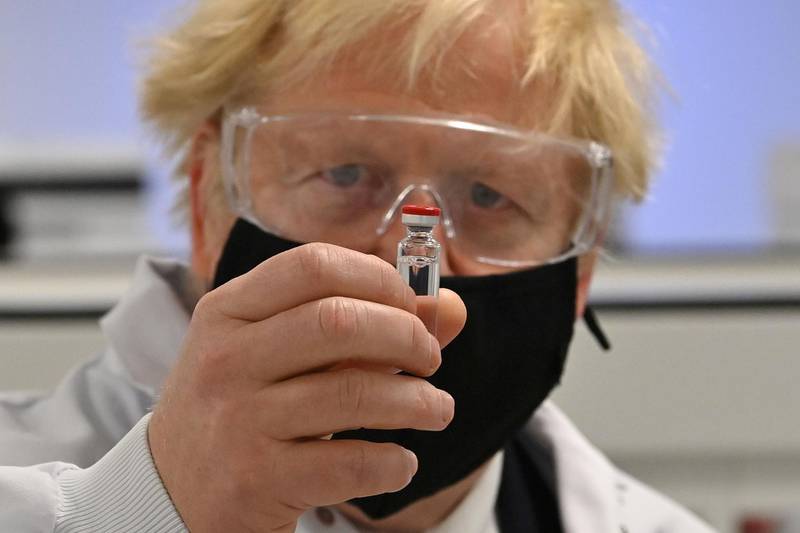 Britain's Prime Minister Boris Johnson poses for a photograph with a vial of the AstraZeneca/Oxford University COVID-19 candidate vaccine, known as AZD1222, at Wockhardt's pharmaceutical manufacturing facility in Wrexham, north Wales, on November 30, 2020. Britain's Government in August announced a deal with global pharmaceutical and biotechnology company Wockhardt, to increase capacity in a crucial part of the manufacturing process for Covid-19 vaccines. Britain has been Europe's worst-hit country during the pandemic, recording more than 57,000 deaths from some 1.6 million cases. / AFP / POOL / Paul ELLIS

