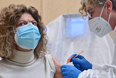 A woman receives a shot of the Pfizer-BioNTech Covid-19 vaccine at Molinette hospital in Turin, Italy. EPA.