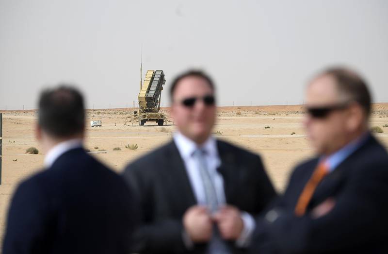 (FILES) In this file photo taken on February 20, 2020 Security for US Secretary of State Mike Pompeo (L) is pictured near a Patriot missile battery as he visits the Prince Sultan air base in Al-Kharj, in central Saudi Arabia. The US is pulling out four of its powerful Patriot missile systems from Saudi Arabia, after determining the threat from Iran that sparked an arms buildup in the region last year had waned, a Defense Department official said May 7, 2020. / AFP / ANDREW CABALLERO-REYNOLDS
