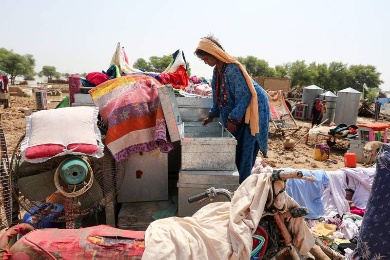 A woman goes through her belongings next to the ruins of
her house after heavy monsoon rains in Rajanpur district, Punjab province. AFP