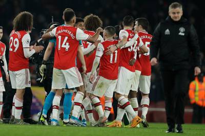 Arsenal players celebrate as Manchester United manager Ole Gunnar Solskjaer walks off. AP