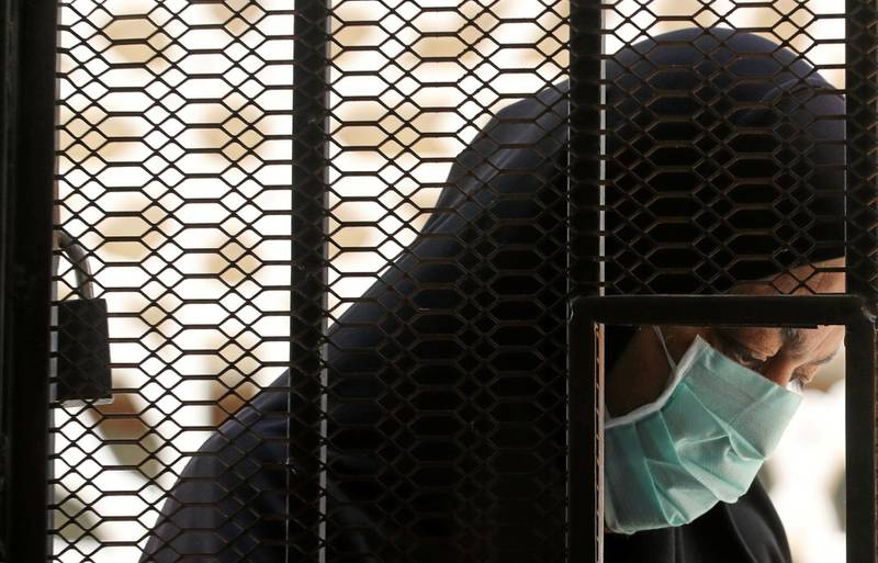 A woman who is in a contact with people who have contracted the coronavirus disease (COVID-19) wears a protective face mask as she waits behind iron bars to receive free medicine provided by the Ministry of Health, at a medical centre in Cairo, Egypt June 3, 2020. Picture taken June 3, 2020. REUTERS/Mohamed Abd El Ghany