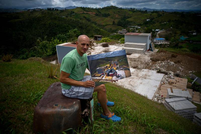 Rafael Reyes holds a printed photo of him taken on October 7, 2017. The 41-year-old father and husband has been living with his in-laws and says he plans to rebuild his home with US federal assistance. All photos by Ramon Espinosa / AP Photo