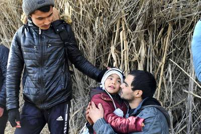 A man hugs a child upon their arrival at the village of Skala Sikaminias, on the Greek island of Lesbos, after crossing the Aegean sea from Turkey with other migrants, on Friday, Feb. 28, 2020. An air strike by Syrian government forces killed scores of Turkish soldiers in northeast Syria, a Turkish official said Friday, marking the largest death toll for Turkey in a single day since it first intervened in Syria in 2016. (AP Photo/Micheal Varaklas)