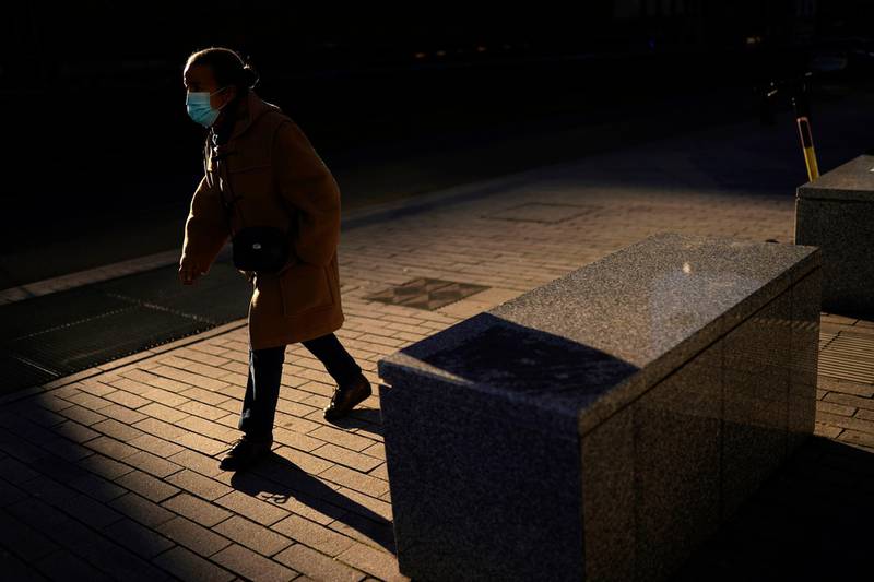 A woman, wearing a face mask to prevent the spread of the coronavirus, walks along the European quarter in Brussels. AP Photo