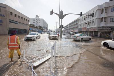 Motorists and pedestrians deal with the heavy flooding in Sharjah. Antonie Robertson / The National