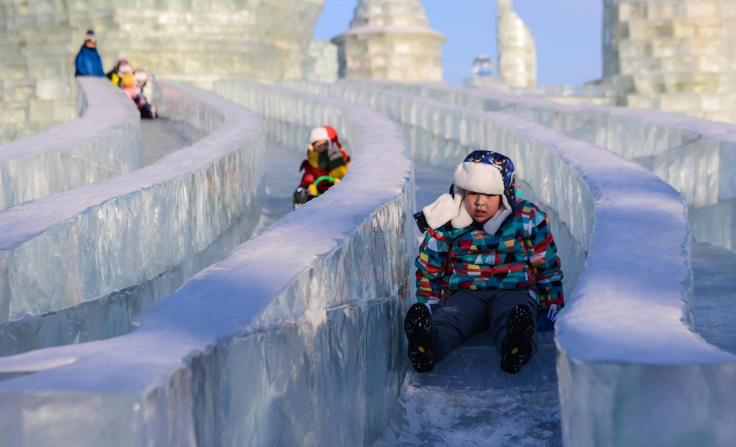 HARBIN, CHINA - JANUARY 16: Children enjoy the ice slides during the 33rd Harbin International Ice and Snow Festival at Harbin Ice And Snow World in Harbin, China on January 16, 2017. The Festival, established in 1985, is held annually on January 5 and lasts over a month. (Photo by Zhong Zhenbin/Anadolu Agency/Getty Images)