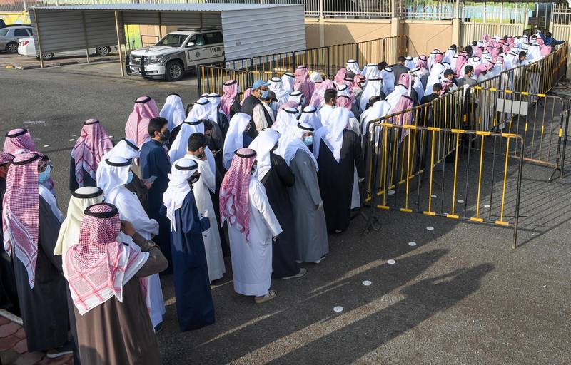 People wearing protective masks arrive to cast their vote at a polling station in Kuwait City. EPA