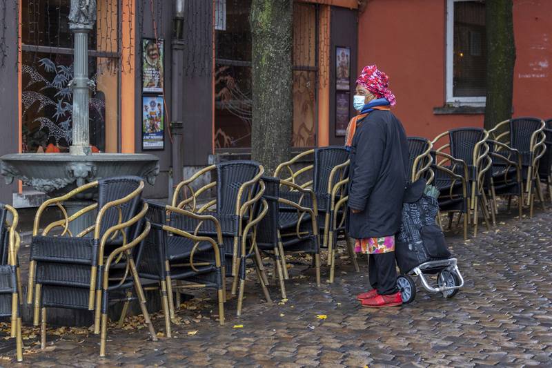 A woman passes by an empty terrace in the Marrolles quarter in Brussels, Belgium. AP Photo
