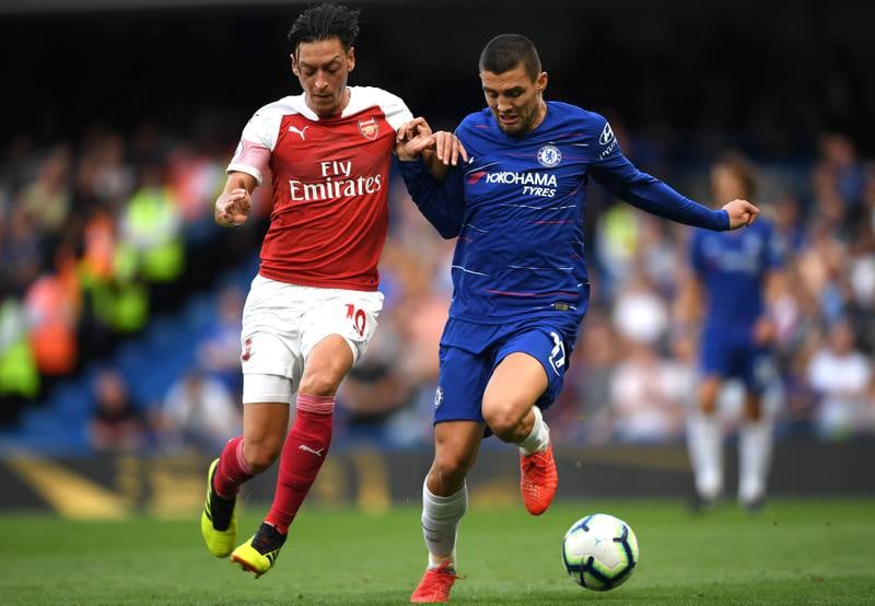 LONDON, ENGLAND - AUGUST 18:  Mesut Ozil of Arsenal battles for possession with Mateo Kovacic of Chelsea during the Premier League match between Chelsea FC and Arsenal FC at Stamford Bridge on August 18, 2018 in London, United Kingdom.  (Photo by Shaun Botterill/Getty Images)