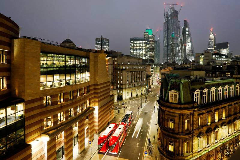 The One Poultry building, housing a WeWork Cos. co-working space, left, stands illuminated at dusk in the City of London, U.K., on Thursday, Nov. 22, 2018. Brexit Britain will be the top destination for major European investors to snap up commercial property next year, according to a survey of executives managing more than 500 billion pounds ($640 billion) of real estate conducted by Knight Frank. Photographer: Luke MacGregor/Bloomberg