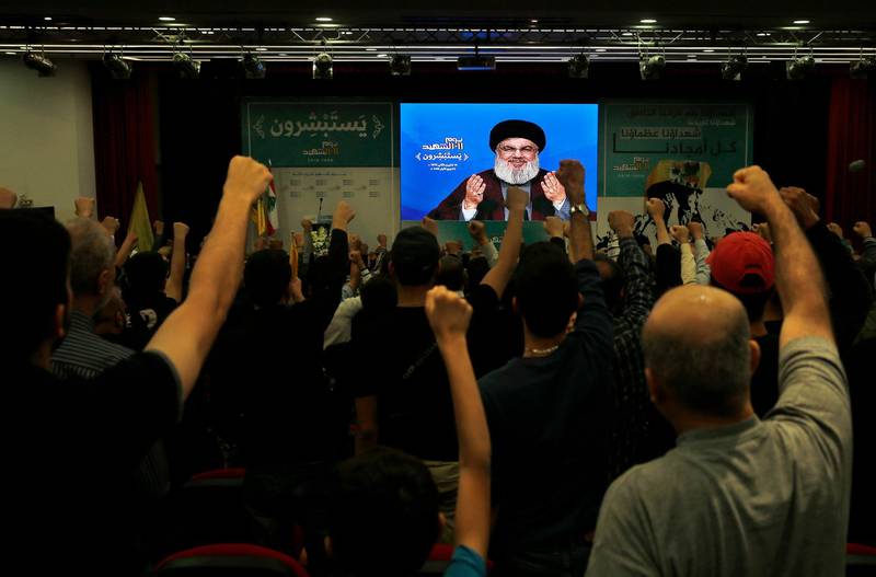 Supporter of the Iranian-backed Hezbollah group raise their fists and cheer as they listen to a speech of Hezbollah leader Sayyed Hassan Nasrallah, via a video link, during a rally marking Hezbollah Martyr's Day, in a southern suburb of Beirut, Lebanon, Saturday, Nov. 10, 2018. (AP Photo/Bilal Hussein)