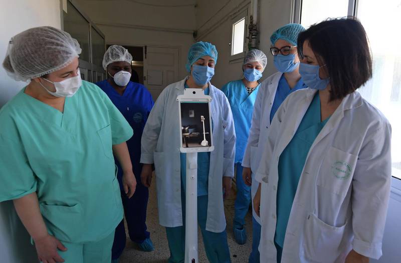 The medical staff at the Mami hospital interact with a robot, manufactured by a Tunisian company and donated to the hospital to support their efforts in combatting the coronavirus.  AFP